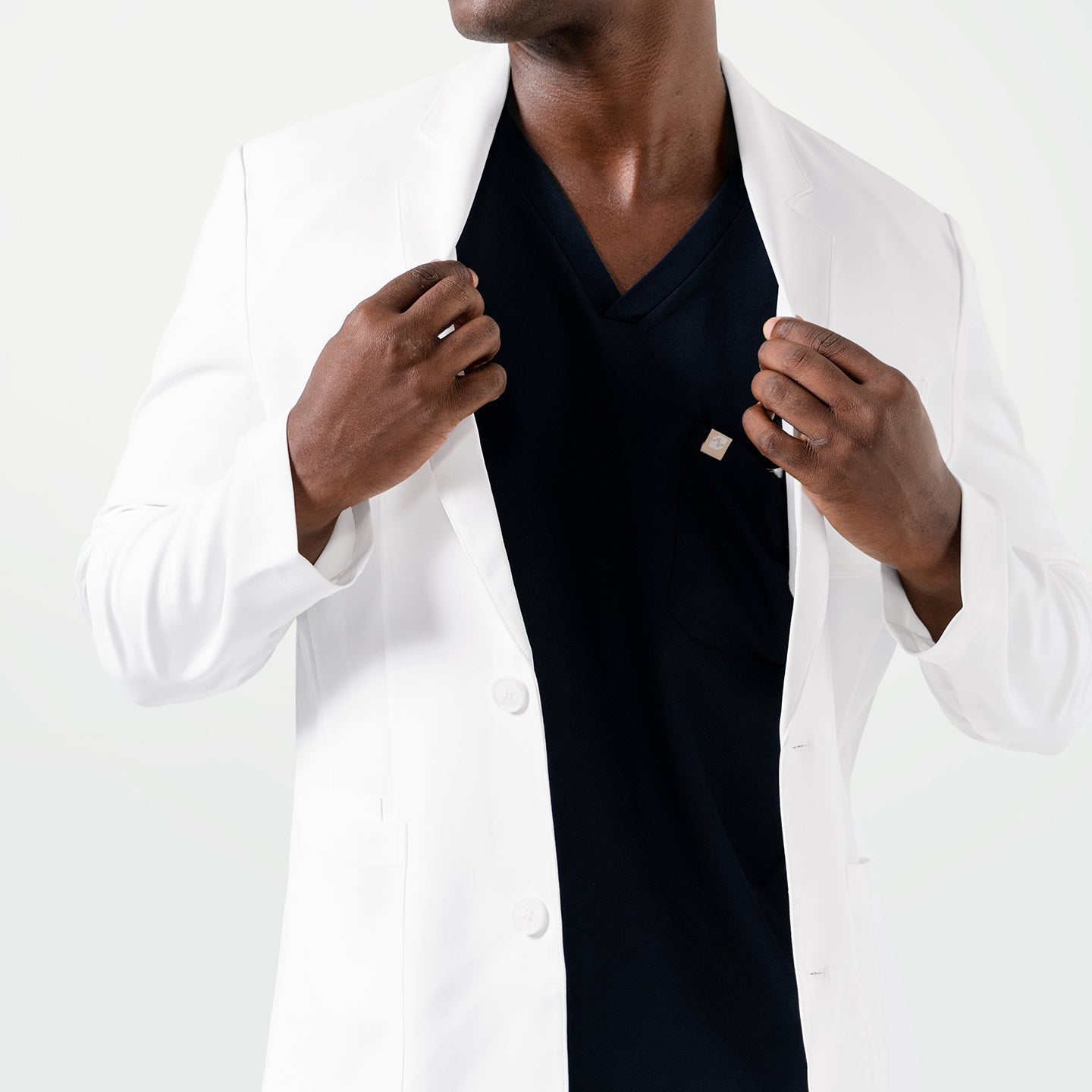Image of With both hands holding the lapels, the model showcases the sleek fit of the Men’s LCM-100 Lab Coat.